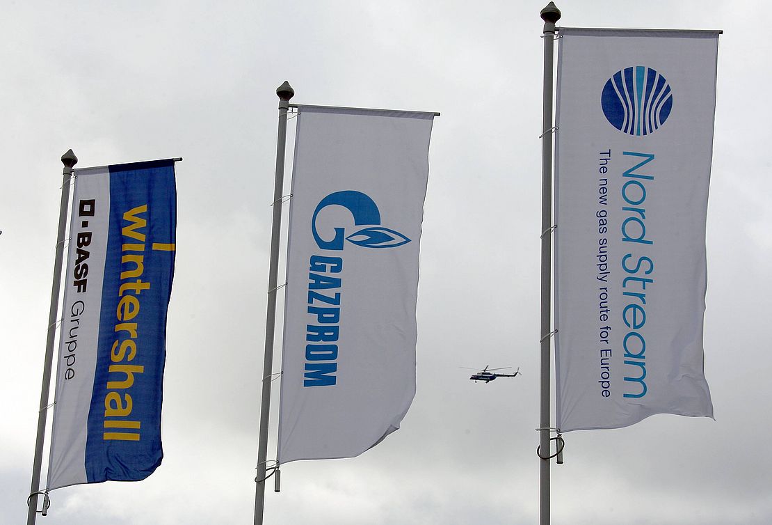 Drei Flaggen nebeneinander aufgestellt: "Wintershall BASF", "Gazprom" und "Nord Stream: The New Gas Supply Route For Europe".