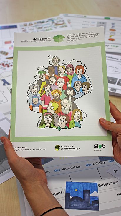 Cover Starterpaket Cover des Heftes "Starterpaket zum Einstieg in den deutschen Alltag". Daneben die Beschreibung "Handreichung für ehrenamtliche Sprachvermittler in ersten Orientierungs- und Sprachangeboten für Geflüchtete und Asylsuchende. Darunter die Autorinnen: Sieglinde Eichert und Anne Potzel. Daneben die Herausgeberschaft: Sächsischer Ausländerbeauftragter und SLpB.