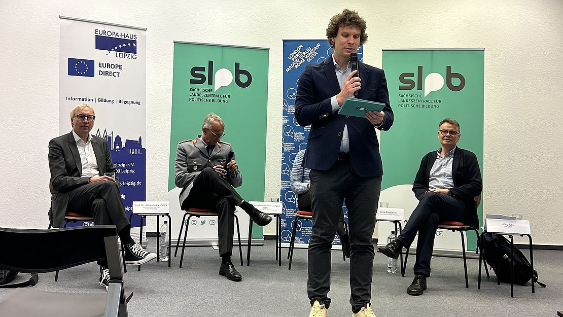 Ivo Vacík steht vor den Gästen des Podiums und begrüßt das Publikum