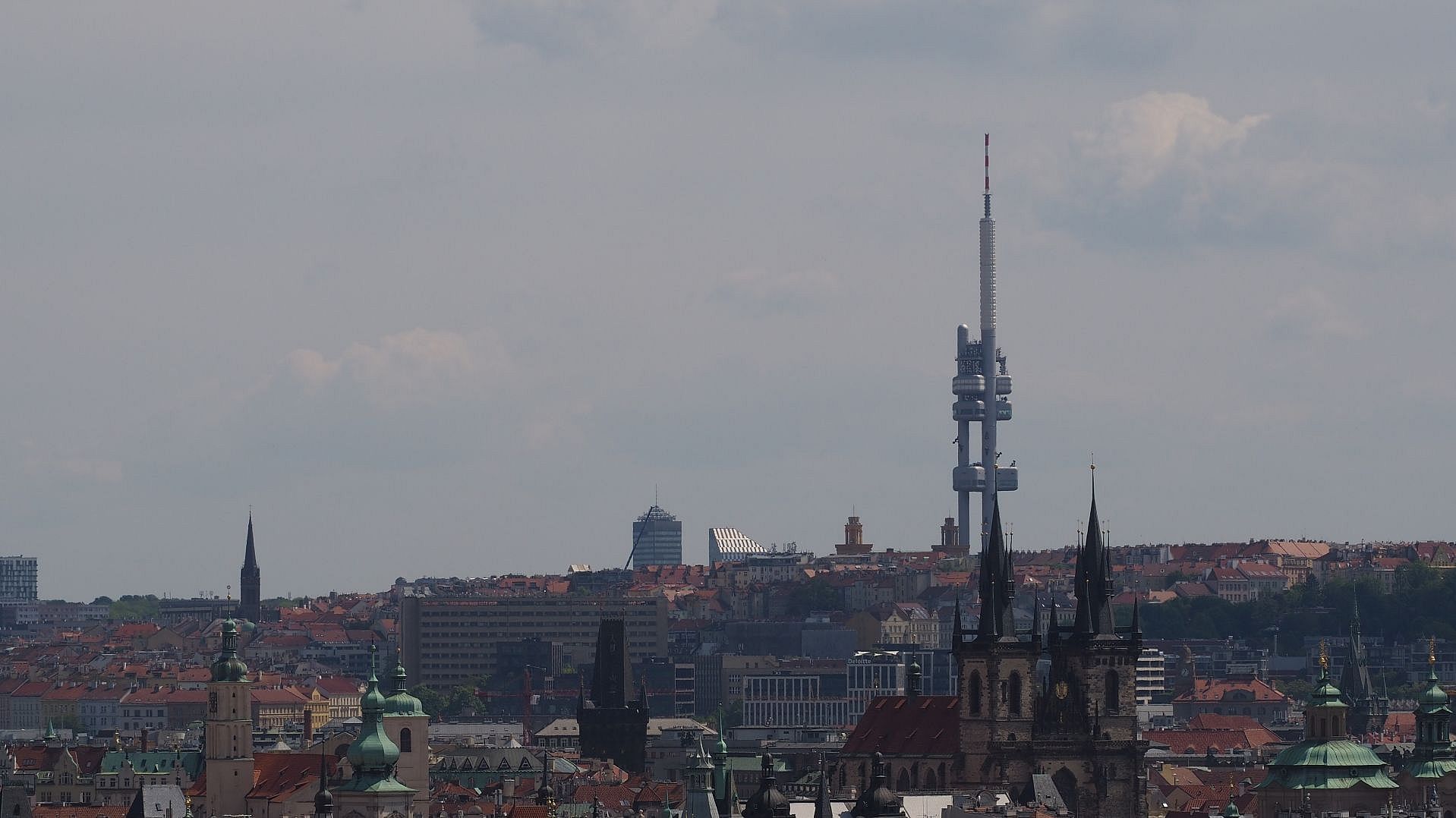 im Vordergrund die Dächer von Prag. Im Hintergrund der Fernsehturm im Stadteil Žižkov.