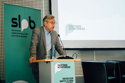 Dr. Roland Löffler am Podium der Partnerkonferenz 2023 während seines Grußwortes