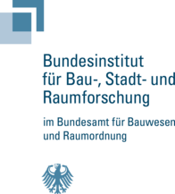 Das Bild zeigt das Logo des Bundesinstituts für Bau-, Stadt- und Raumforschung. Der Text ist in zwei Teile gegliedert. Im oberen Teil steht "Bundesinstitut für Bau-, Stadt- und Raumforschung" in Großbuchstaben in einer blauen Farbpalette. Direkt darunter, in kleinerer Schrift, steht "im Bundesamt für Bauwesen und Raumordnung". Bei Klick Weiterleitung auf die Website des BBSR.