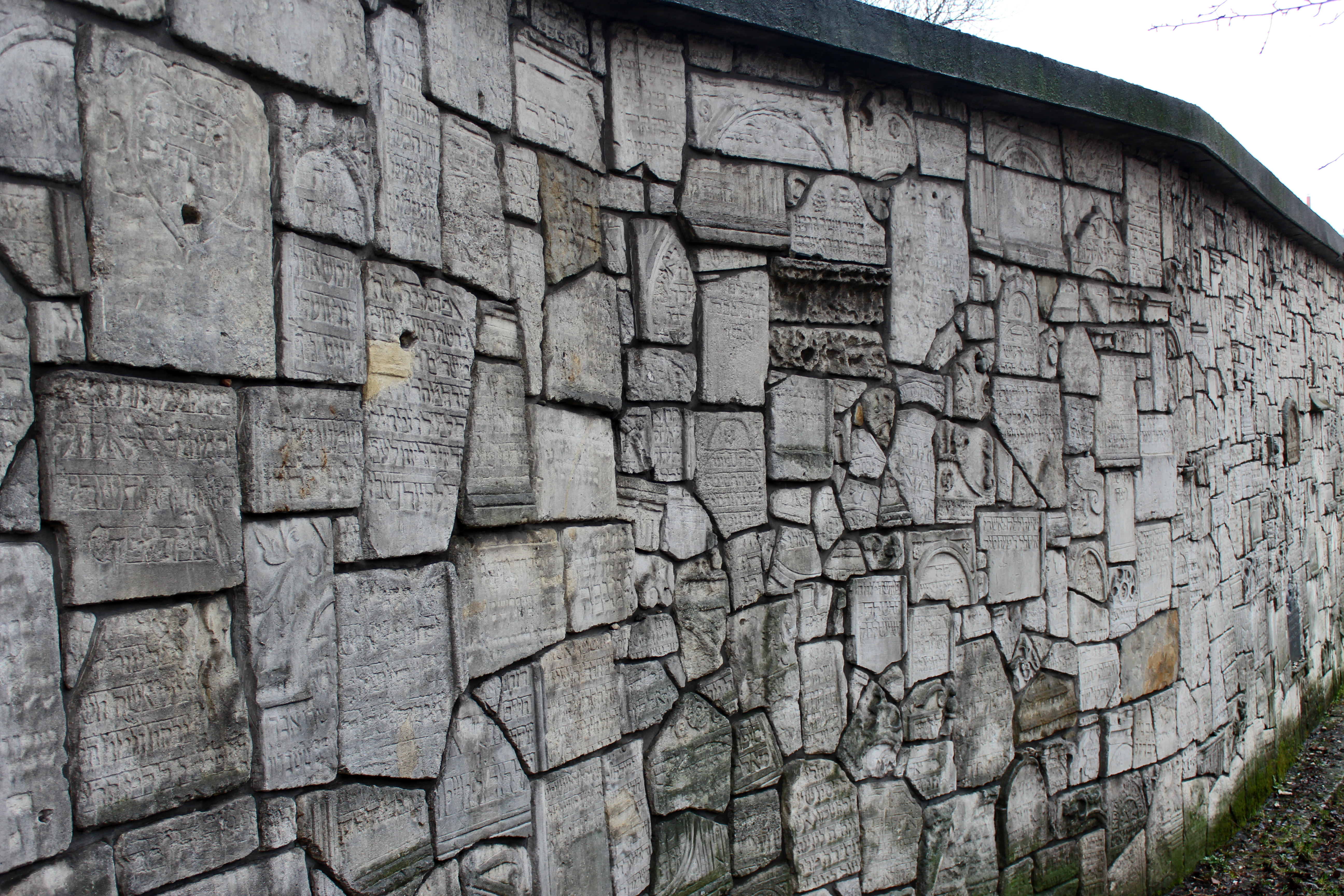 Eine Mauer, jeder Stein voller Gravuren hebräischer Inschriften.