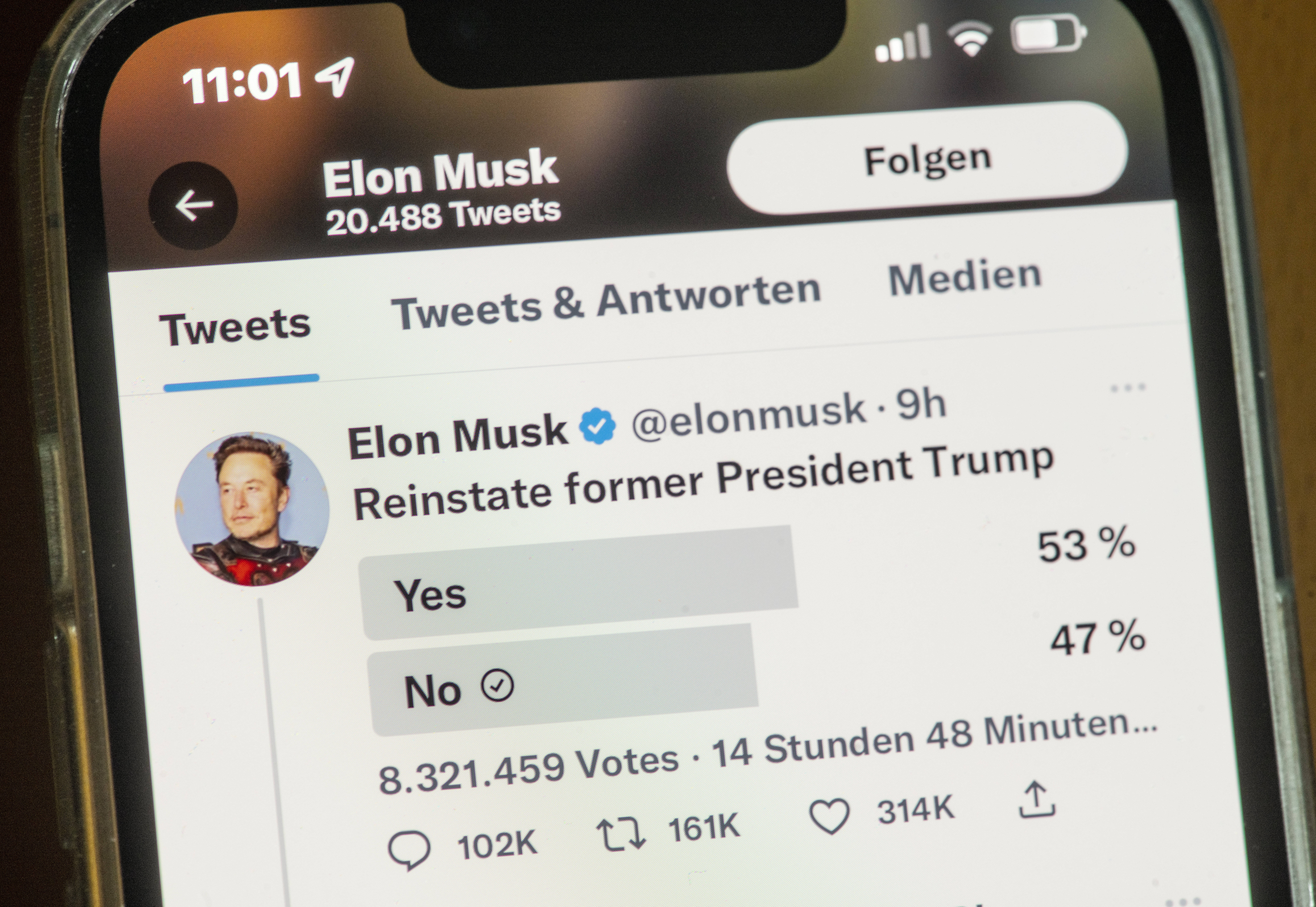 Ein Smartphonebildschirm, auf dem eine Twitter-Umfrage des Inhabers Elon Musk zu sehen ist, ob der ehemalige Präsident Donald Trump wieder für die Plattform zugelassen werden soll. Ja: 53%, Nein (auch durch den:die Nutzer:in angekreuzt) 47%.