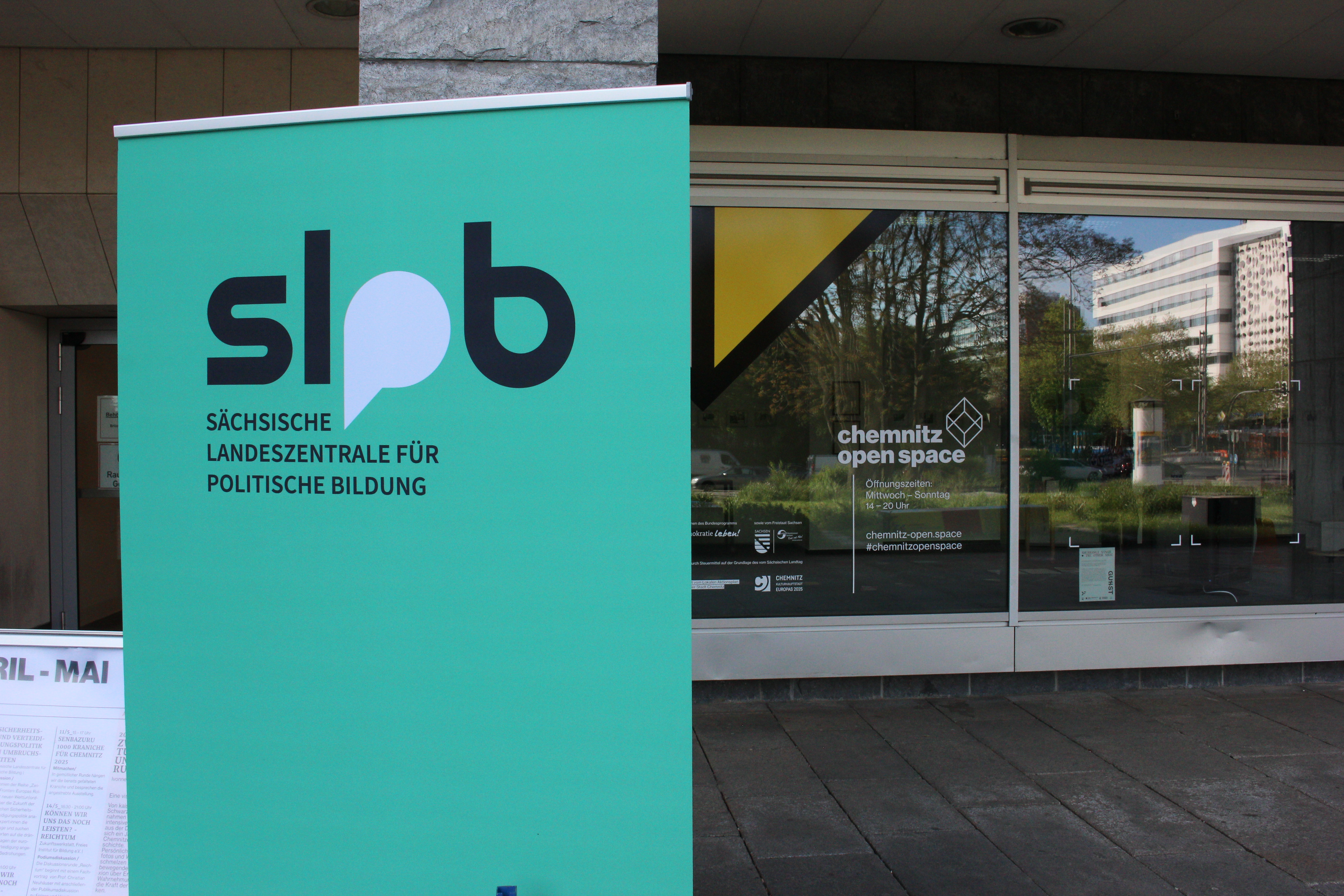 Roll Up der SLpB steht vor der Glasfassade des Open Space in Chemnitz